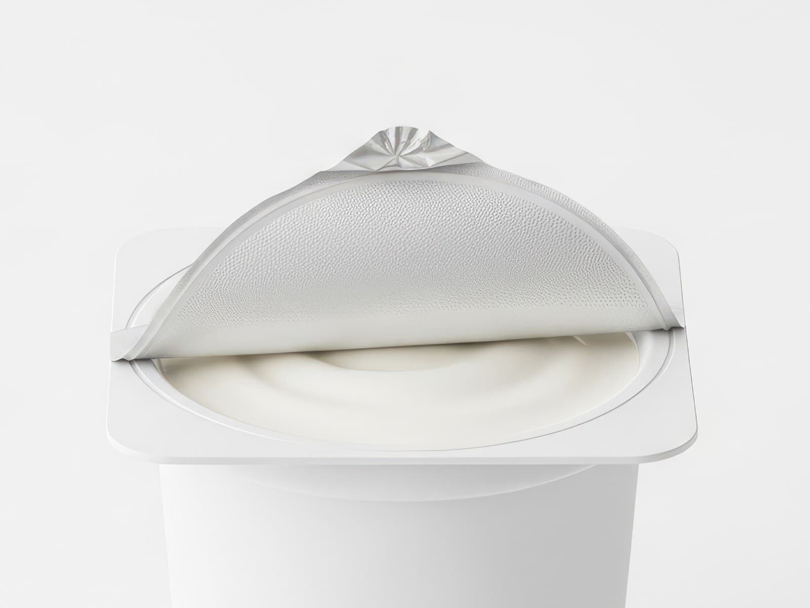 Peeled aluminium foil lid on a sealed dairy portion pack